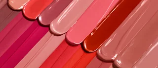 Des bandes de vernis a ongles dans une variete de teintes de rose, allant du nude au rouge.