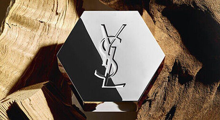 Flacon de parfum YSL hexagonal sur du bois.