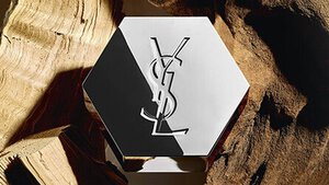 Flacon de parfum YSL hexagonal sur du bois.