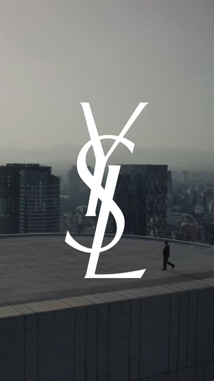 Logo YSL sur un toit avec skyline au coucher du soleil