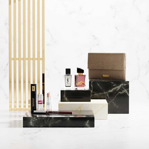 Produits de beaute YSL sur socles en marbre de luxe.