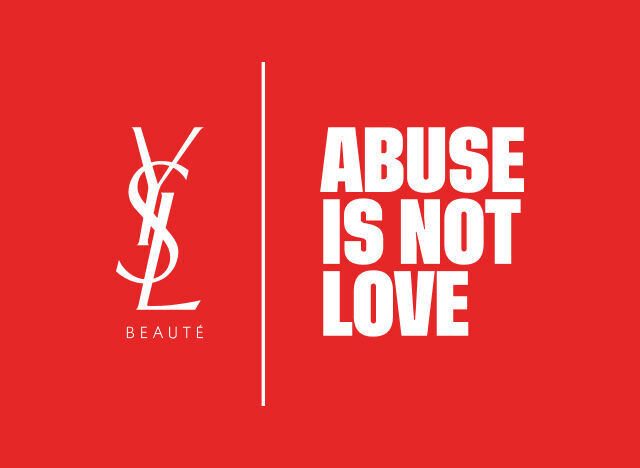 Logo YSL Beaute en blanc et le message "ABUSE IS NOT LOVE" en blanc, separes par une ligne verticale, sur un fond rouge vif.