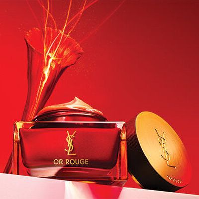 A luxurious jar of cream and an elegant compact on a gradient red background, conveying a sense of richness and elegance.