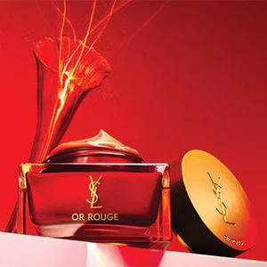 A luxurious jar of cream and an elegant compact on a gradient red background, conveying a sense of richness and elegance.