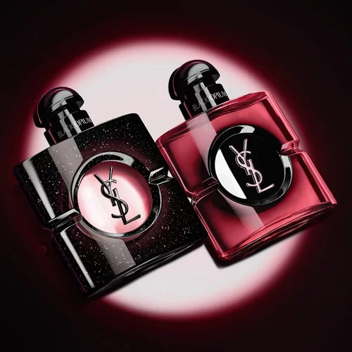 Deux flacons de parfum Black Opium d'Yves Saint Laurent illumines sur fond sombre.