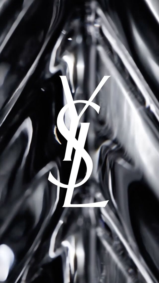 Logo YSL blanc sur fond de verre noir a facettes.