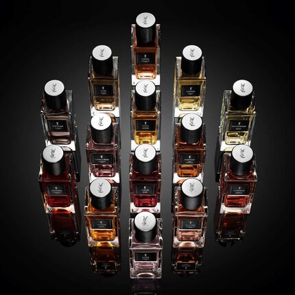 Flacons de parfum YSL disposes en composition geometrique sur fond noir