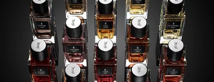 Flacons de parfum YSL disposes en composition geometrique sur fond noir