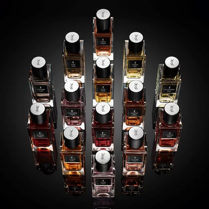 Flacons de parfum YSL disposes en composition geometrique sur fond noir