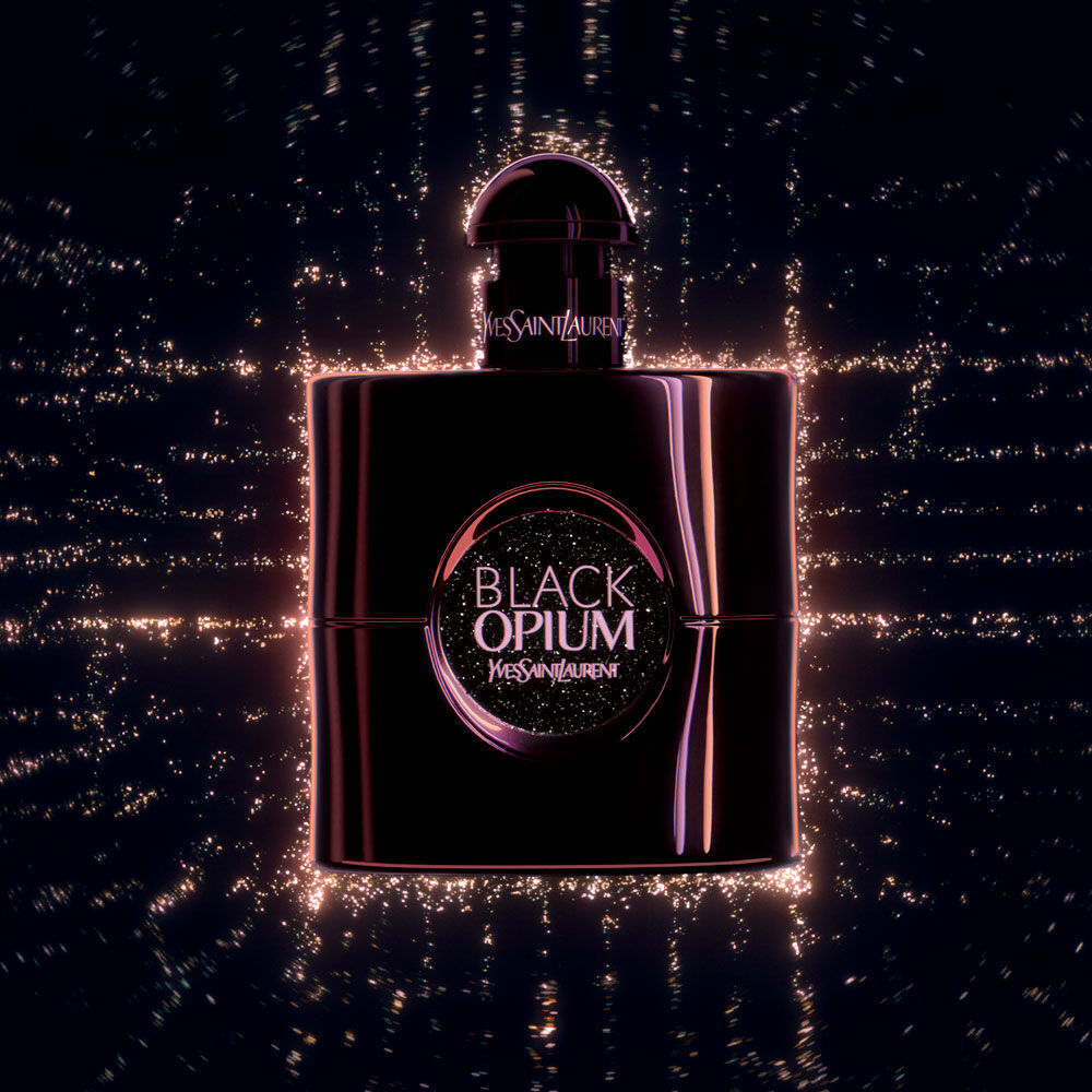 A sleek, dark perfume bottle labeled "Black Opium" by Yves Saint Laurent, featuring a sparkling background with a luminous, ethereal quality.