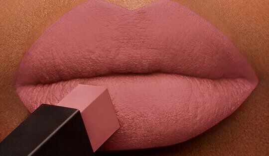 Close-up of smooth lips with a soft, nude lipstick being applied.