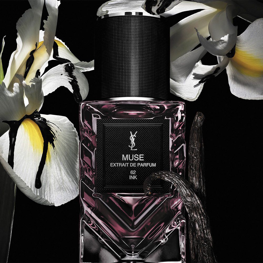 Nouveau flacon Le Vestiaire des Parfums sur fond noir avec des fleurs en arriere-plan.