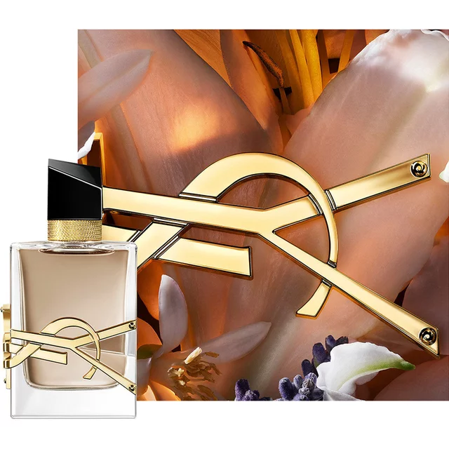 Flacon LIBRE FLOWERS & FLAMES encadre de petales cremeux et du logo YSL dore dans une lumiere chaude.