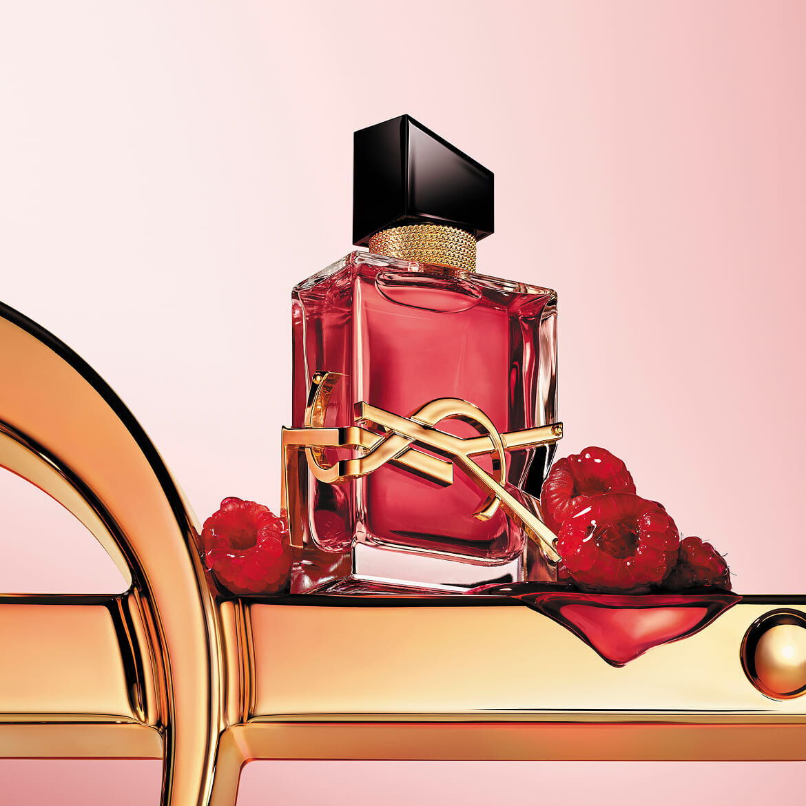 Le flacon ecarlate de YSL LIBRE Berry Crush, avec son essence vibrante, repose sur un majestueux logo dore, entoure de framboises succulentes, promettant une signature audacieuse et irresistible.​