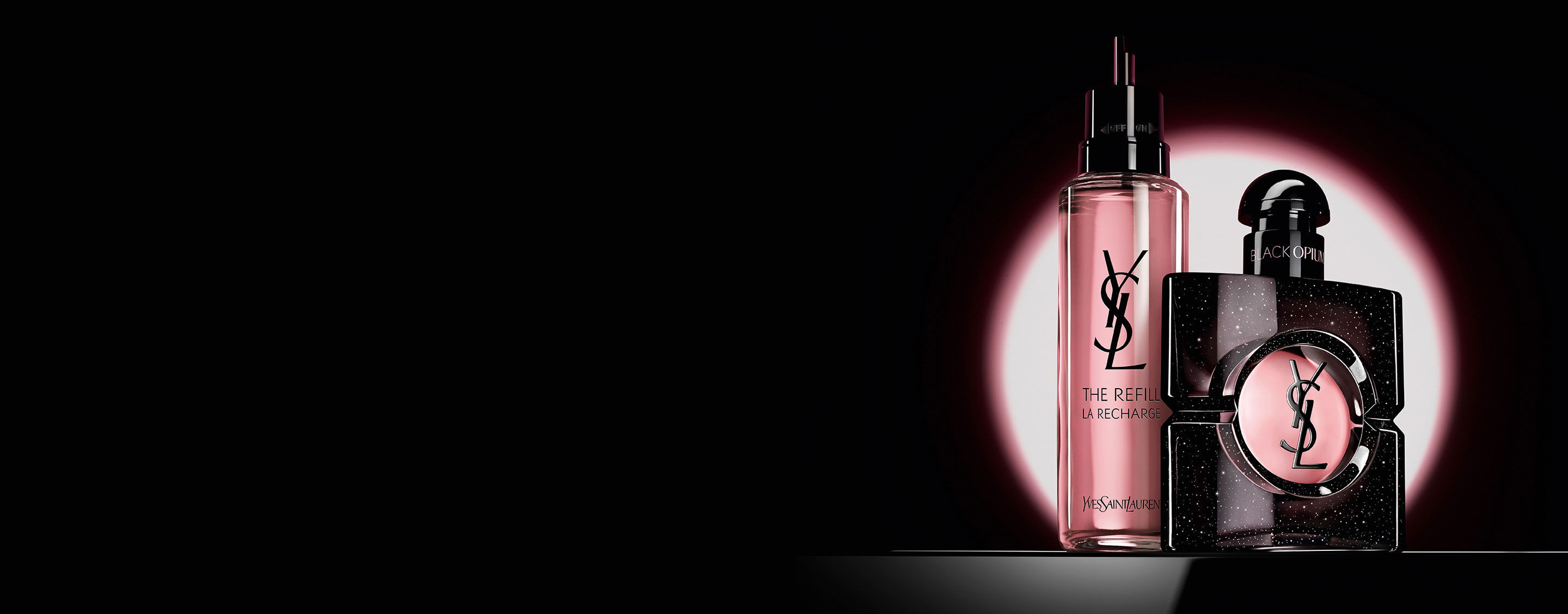Le flacon Black Opium Eau de Parfum presente aux cotes de sa recharge en verre de 100 ml, ornee du logo YSL.