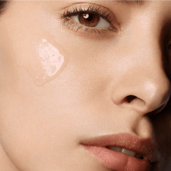 Close-up of a person's face with a smooth application of foundation on one cheek, highlighting their natural skin texture and features.