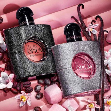 Deux flacons YSL Black Opium sur fond rose avec fleurs et grains de cafe