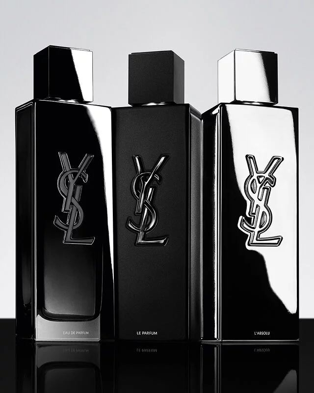 Trois parfums YSL Y pour hommes : Eau de Parfum, Le Parfum et L'Absolu, presentes dans leurs flacons distincts noirs et argentes.