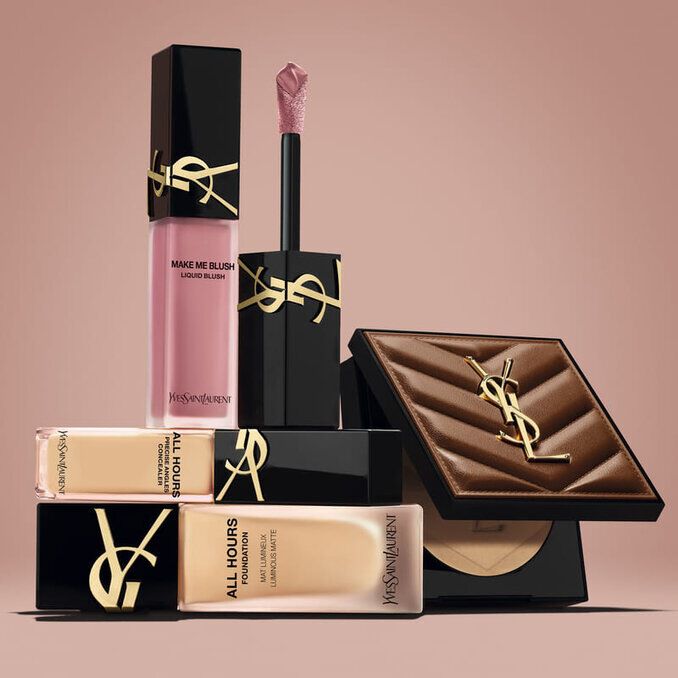 Produits de beaute YSL, dont un blush, un fond de teint et une poudre compacte, sur fond nude.