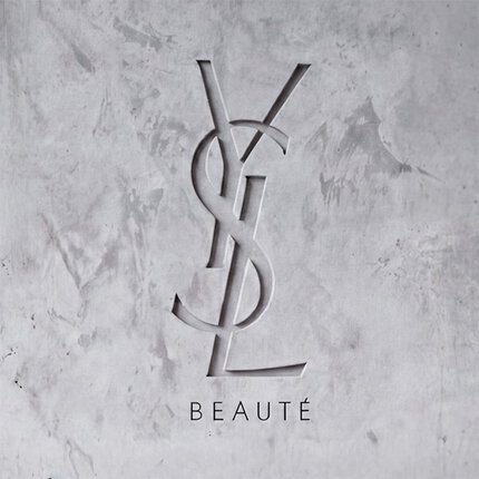 Logo YSL BEAUTE grave dans un mur en beton gris texture.