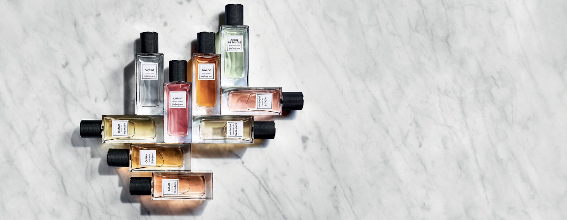 Des flacons de parfum disposes de maniere artistique sur une surface en marbre.