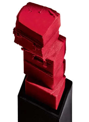 Quatre blocs de rouge a levres empiles, de couleur rouge vif, sur un fond blanc.