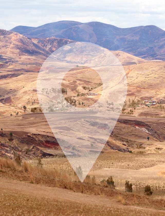 Vue panoramique d'un paysage desertique et vallonne, avec un symbole de localisation au centre.