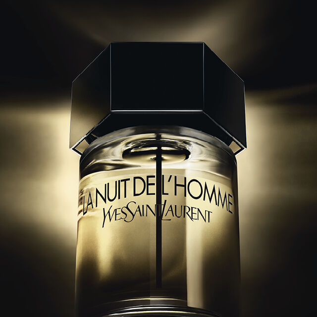 Flacon de parfum "La Nuit de L'Homme" de Yves Saint Laurent, illumine sur fond noir.