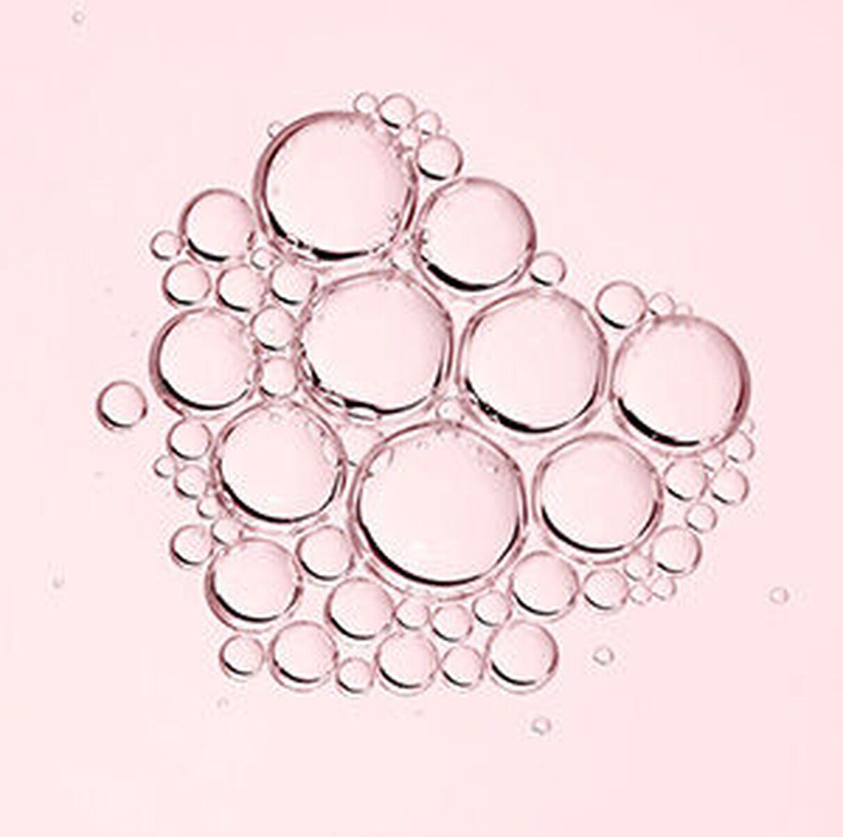 Des bulles de differentes tailles flottent sur un fond rose.