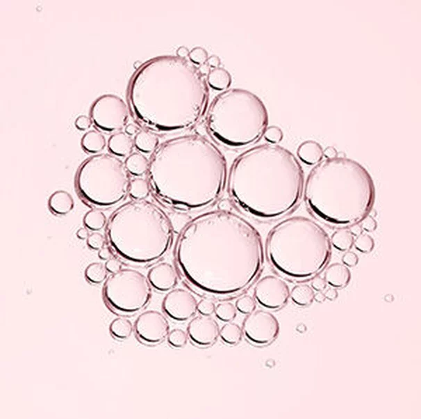 Des bulles de differentes tailles flottent sur un fond rose.
