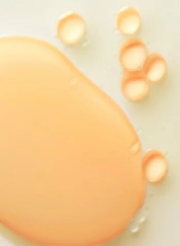 Un melange de gouttes d'huile orange sur un fond clair.
