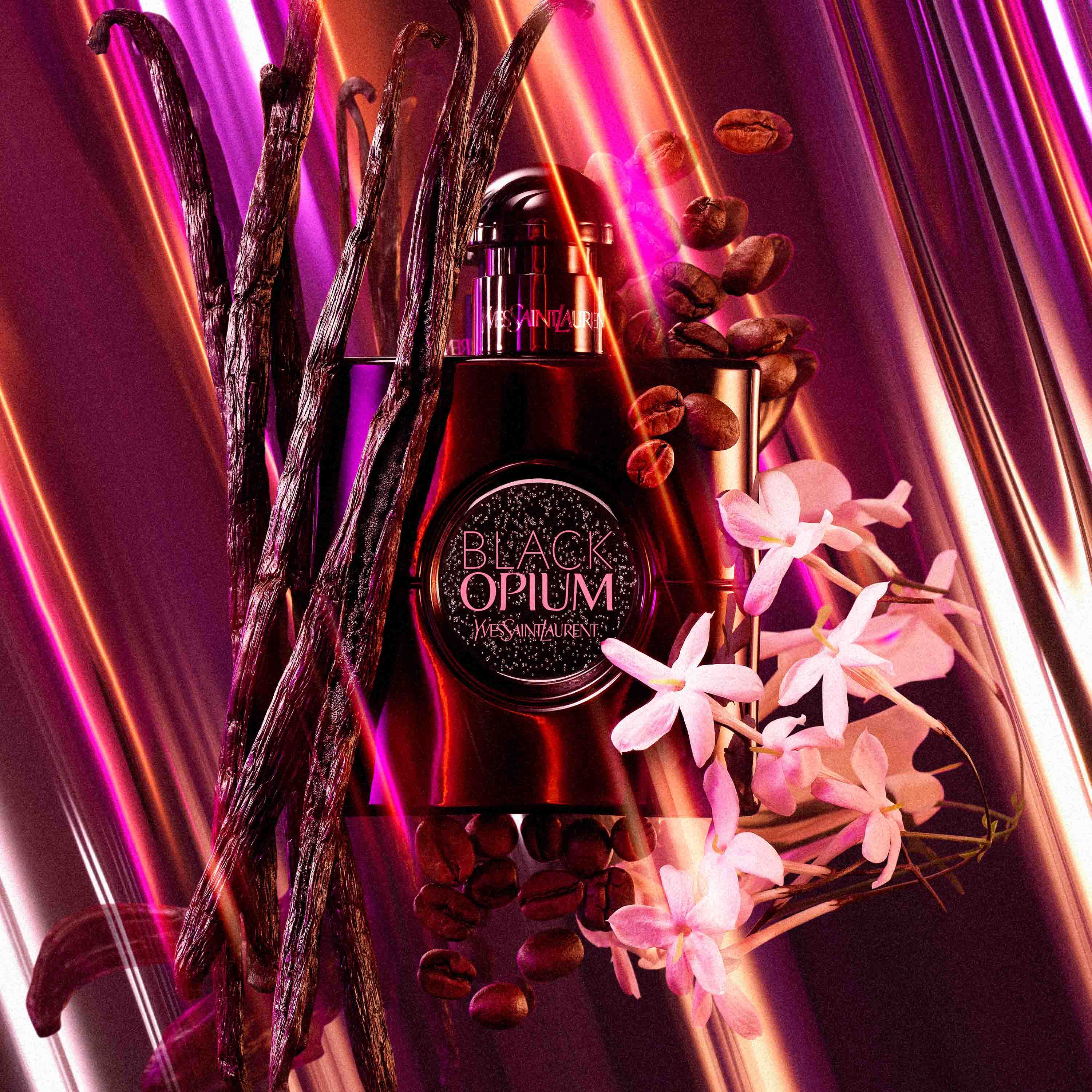 Une bouteille de parfum "Black Opium" de Yves Saint Laurent entouree de fleurs de jasmin, de gousses de vanille et de grains de cafe, le tout sur un fond colore et lumineux.