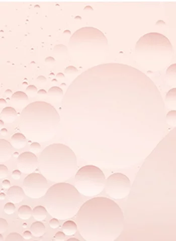 Texte alternatif : Des bulles transparentes de differentes tailles sur un fond rose pale.