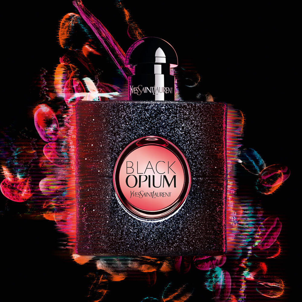 A sleek and stylish bottle of Yves Saint Laurent's Black Opium fragrance, featuring a dark glittery design and a bold pink label, set against a vibrant, abstract background of colorful swirls and lights.