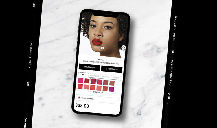 A smartphone displaying a beauty app with a woman’s face and various lipstick shades, set against a marble background.