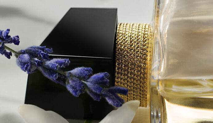 Flacon de parfum elegant avec une etiquette noire, accompagne de fleurs blanches et de brins de lavande.