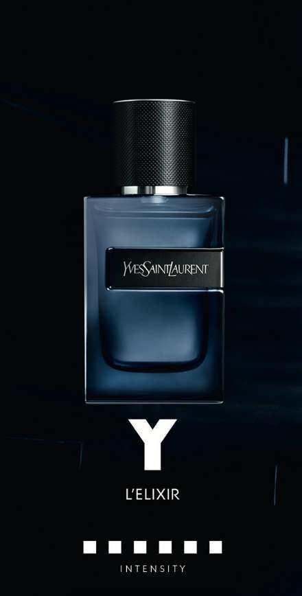 A dark, sleek bottle of Yves Saint Laurent's Y L'Elixir perfume against a black background, featuring a metallic cap and a minimalist design. The label displays the brand name and product title prominently.