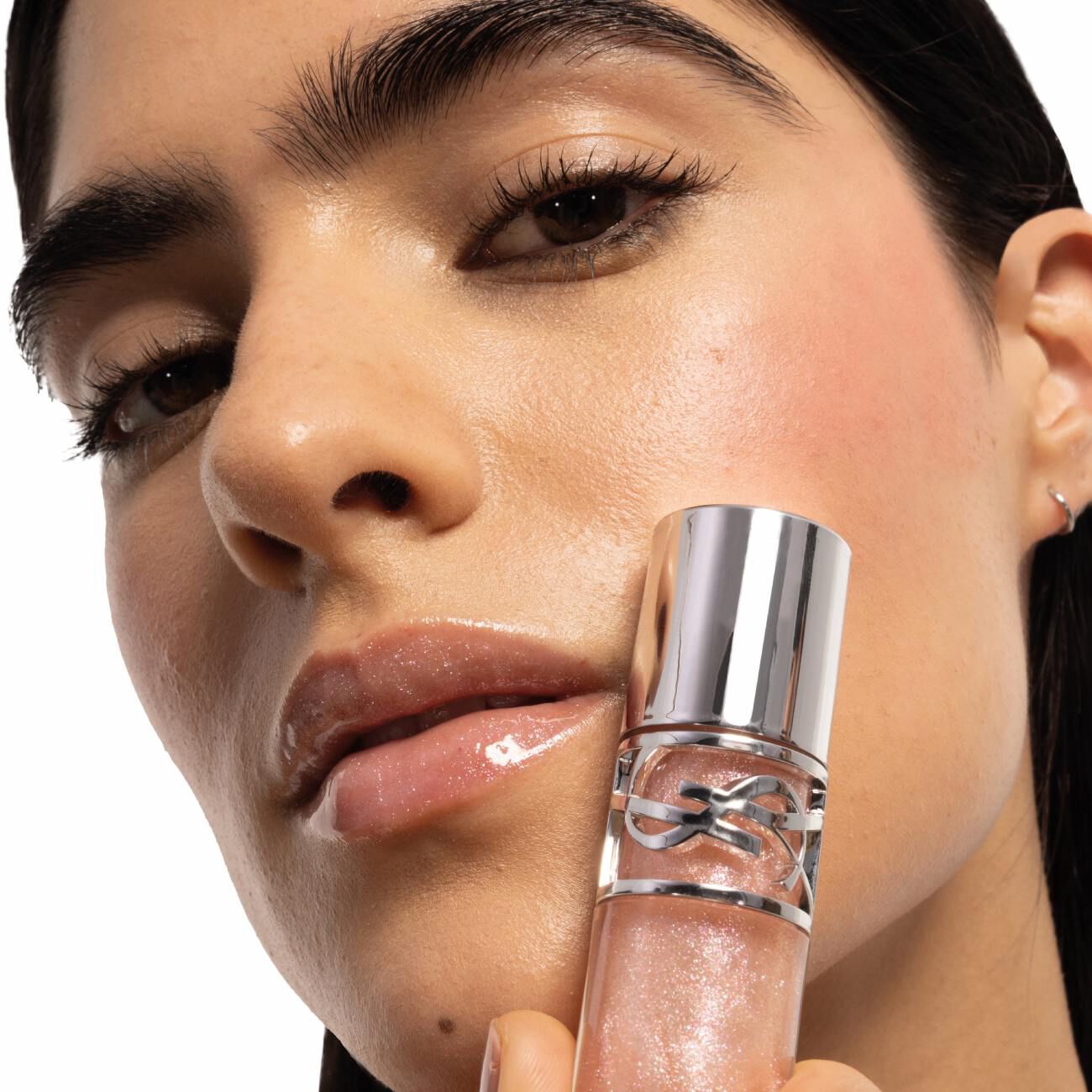 Natalia wearing glossy lips and blush, holding YSL LOVESHINE Plumping Lip Oil Gloss in shade 10, with inset Make Me Blush.