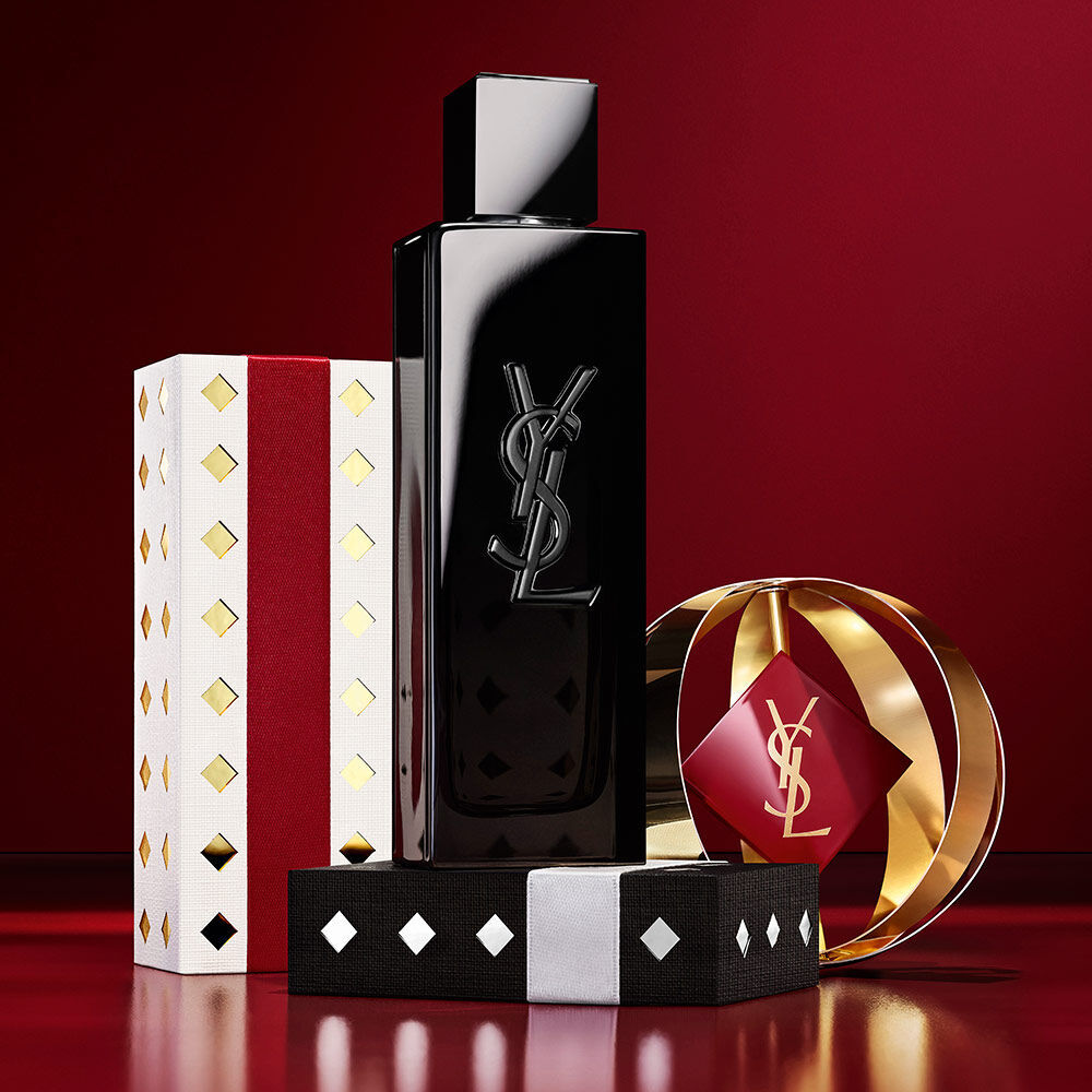 Flacon de parfum MYSLF mis en scene avec des ecrins de fete YSL, or et bordeaux, luxe subversif.