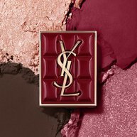 Palette Mini Clutch Couture YSL posee sur un fond texture de fards a paupieres scintillants, poudre #1982 Burgundy Millesime.