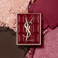 Palette Mini Clutch Couture YSL posee sur un fond texture de fards a paupieres scintillants, poudre #1982 Burgundy Millesime.