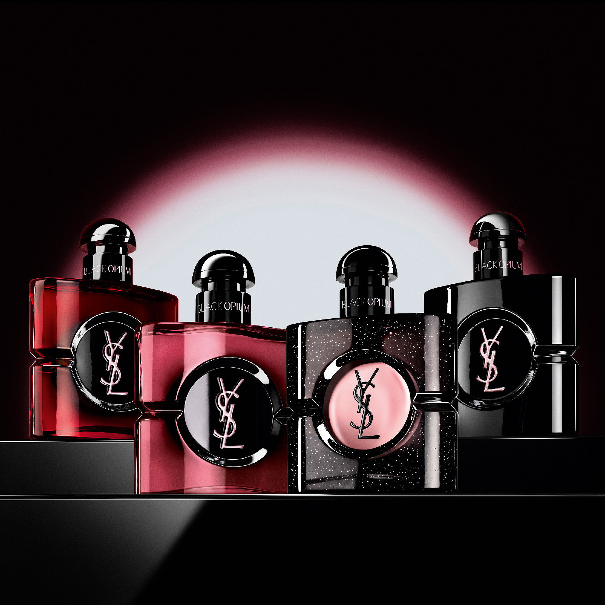Quatre flacons differents de parfum Black Opium alignes sur
                        une surface sombre et reflechissante.
