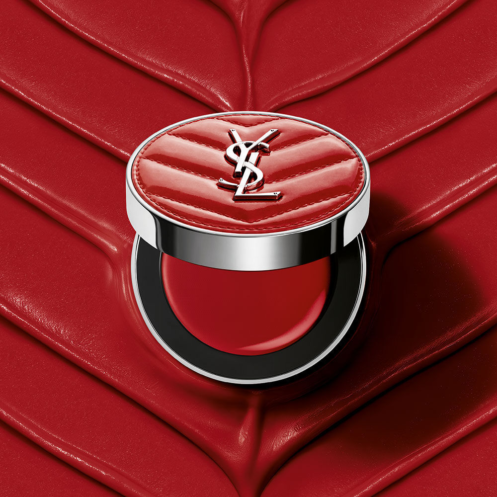Un boitier ouvert de YSL Make Me Blush Lifted Glow Cream Blush, teinte #44 Nude Lavalliere, sur un fond creme texture rose assorti.