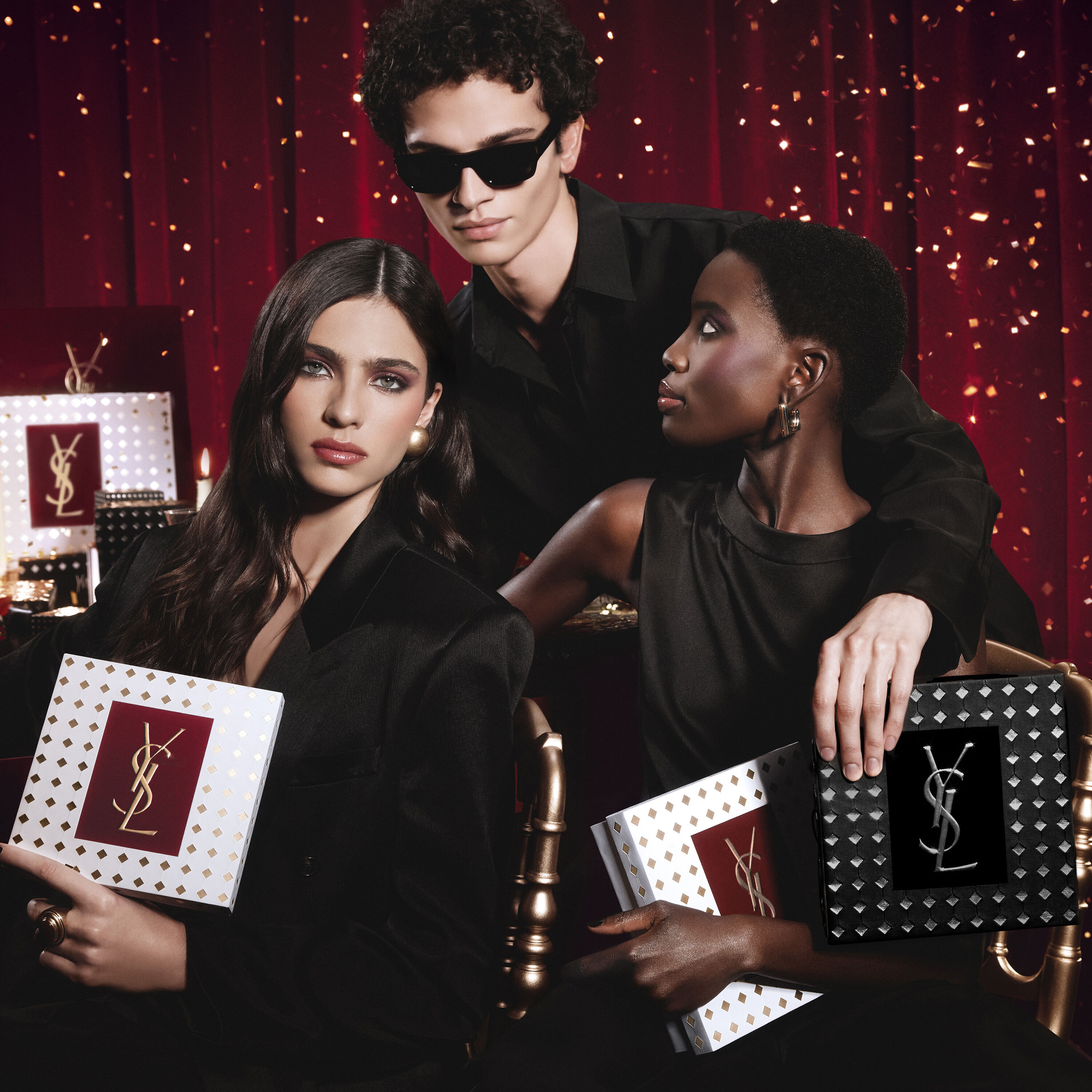 Mannequins reunis, tenant des coffrets cadeaux YSL pour les fetes dans une atmosphere luxueuse et envoutante.