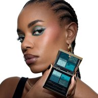 Lizette, YSL Beauty model, holding a YSL Couture Mini Clutch eyeshadow palette, with matching turquoise eye makeup.