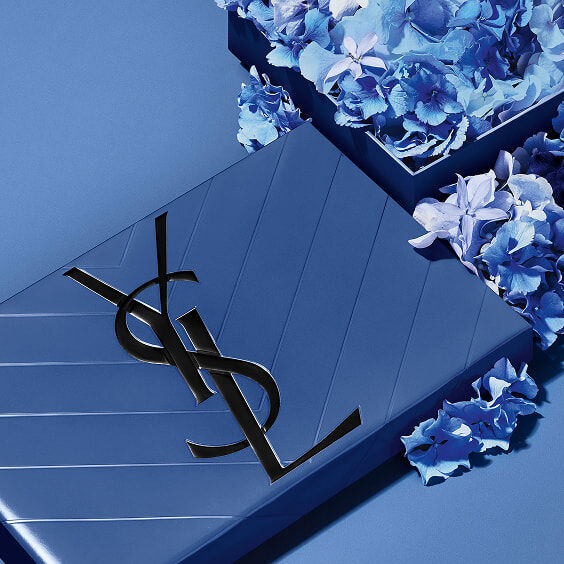 Coffret cadeau YSL bleu pour la Fête des Pères, avec l'iconique logo Cassandre, entouré de délicates fleurs bleues.