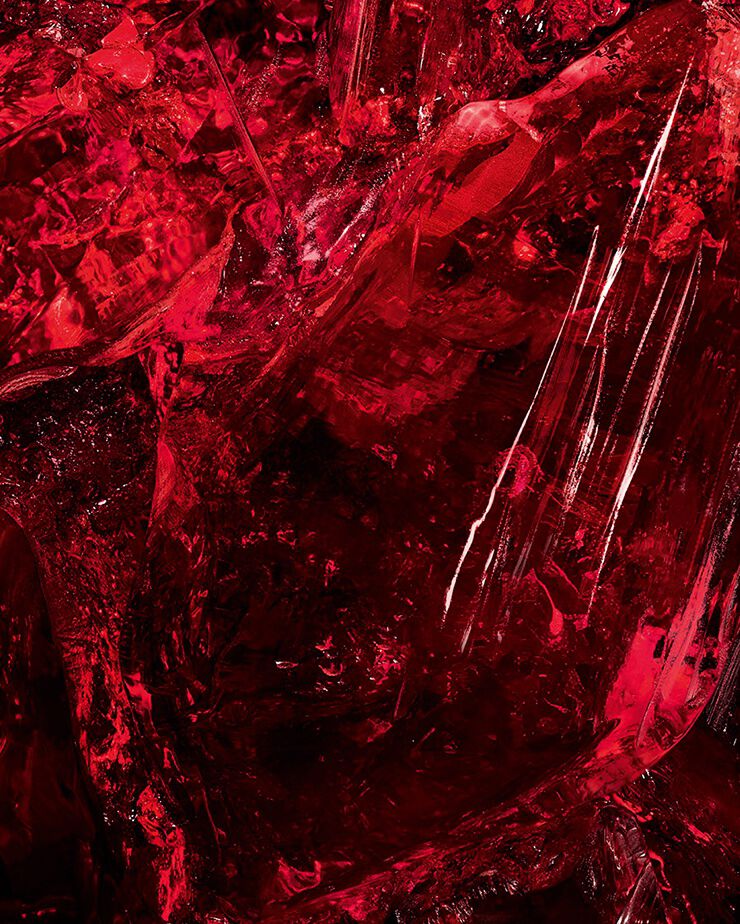 Prise de vue macro d’un cristal d’ambre rouge texturé, un ingrédient clé de CŒUR Eau de Parfum par YSL, montrant sa profondeur brute.