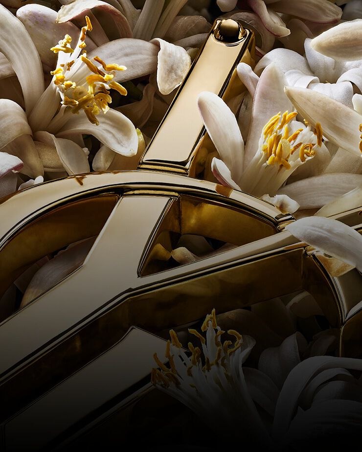 Cassandre YSL dorée avec des fleurs d’oranger blanches.