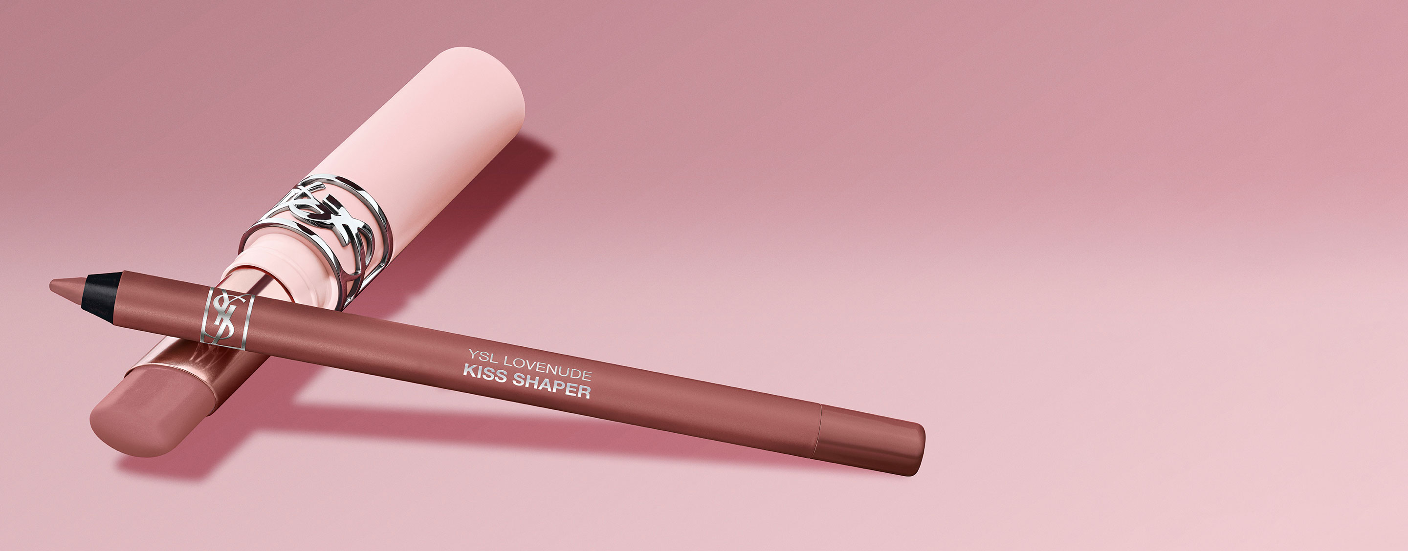 Crayon à lèvres YSL Kiss Shaper et produit pour les lèvres assorti sur fond rose.