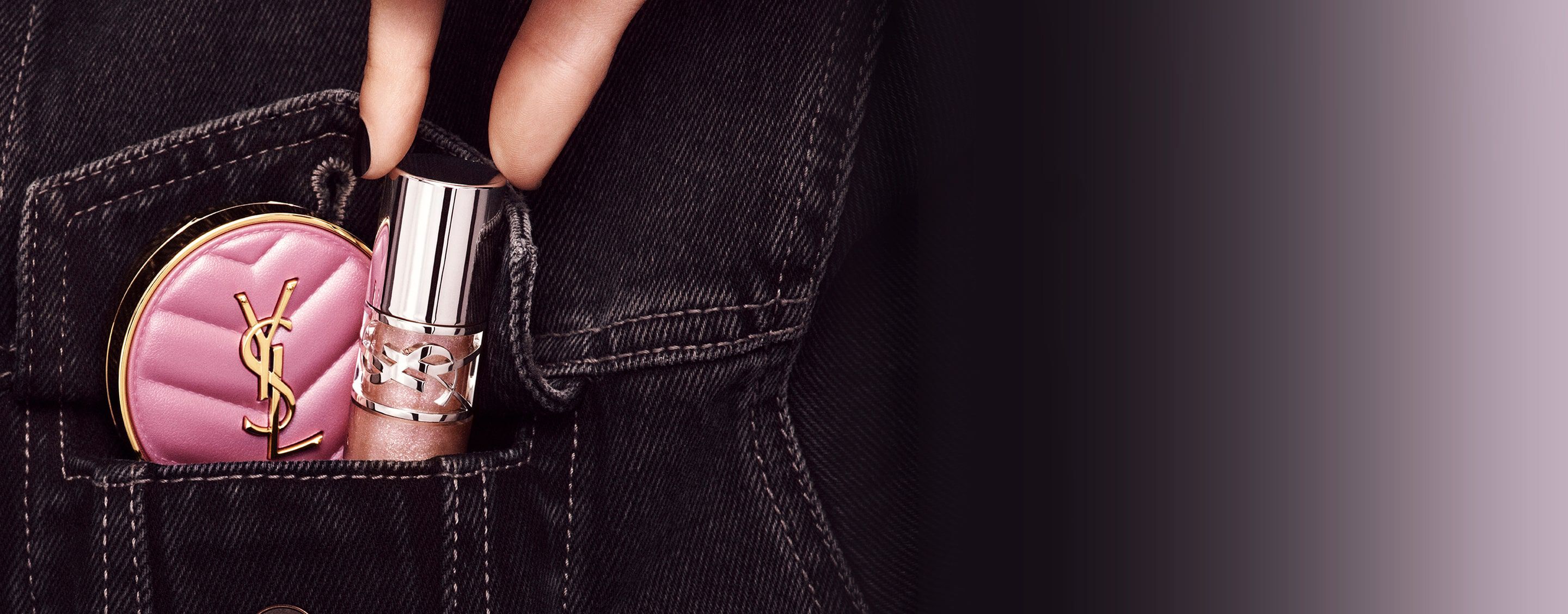 Main glissant le brillant à lèvres YSL LOVESHINE et le poudrier rose Make Me Blush dans une poche de jean